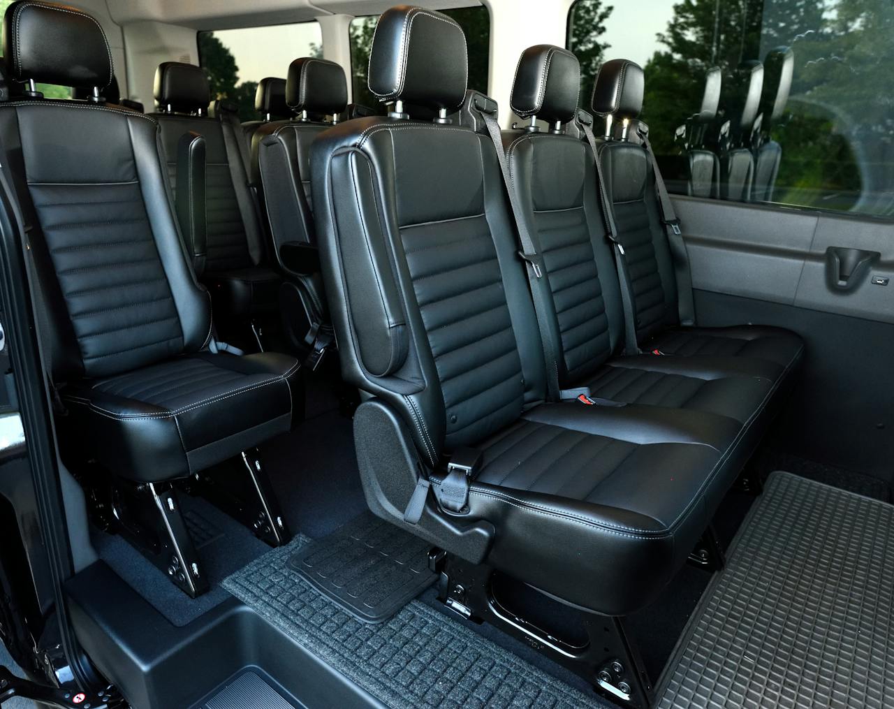 hero-img-01 Luxurious black leather seating inside a spacious minivan with ample legroom.